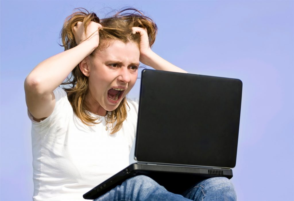 Young woman frustrated at her laptop